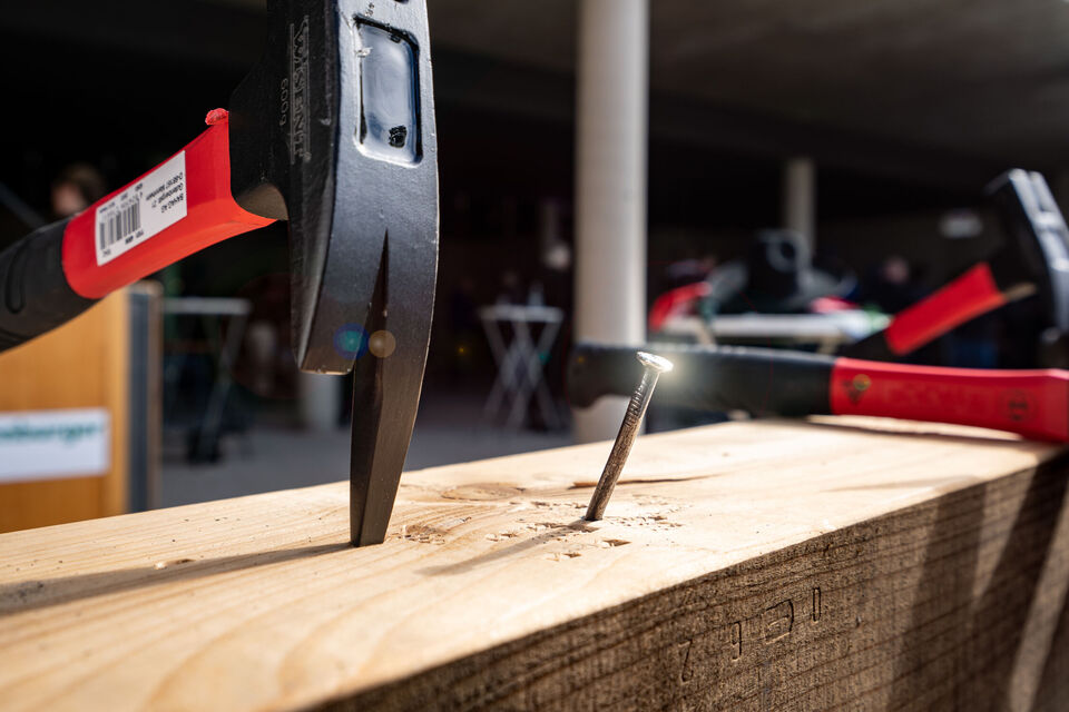 Hammer schlägt in ein Holzblock ein