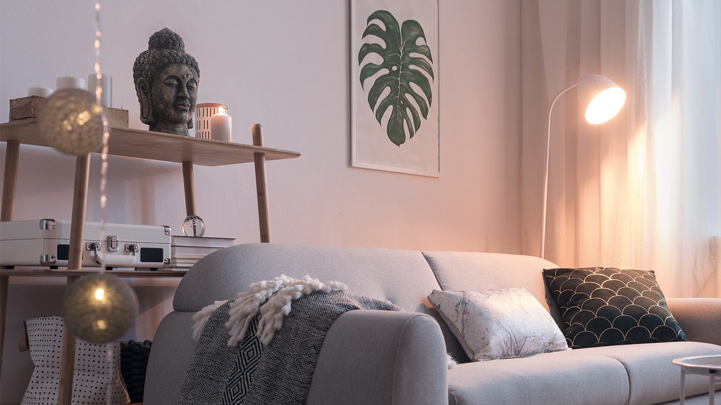 Cozy living room with gray couch, plants and indirect lighting