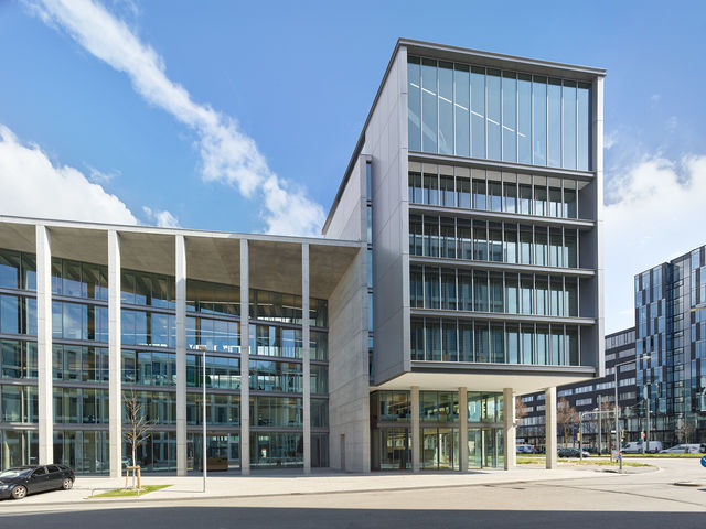 View of the west facade of the building with a cantilevered building element under a blue sky