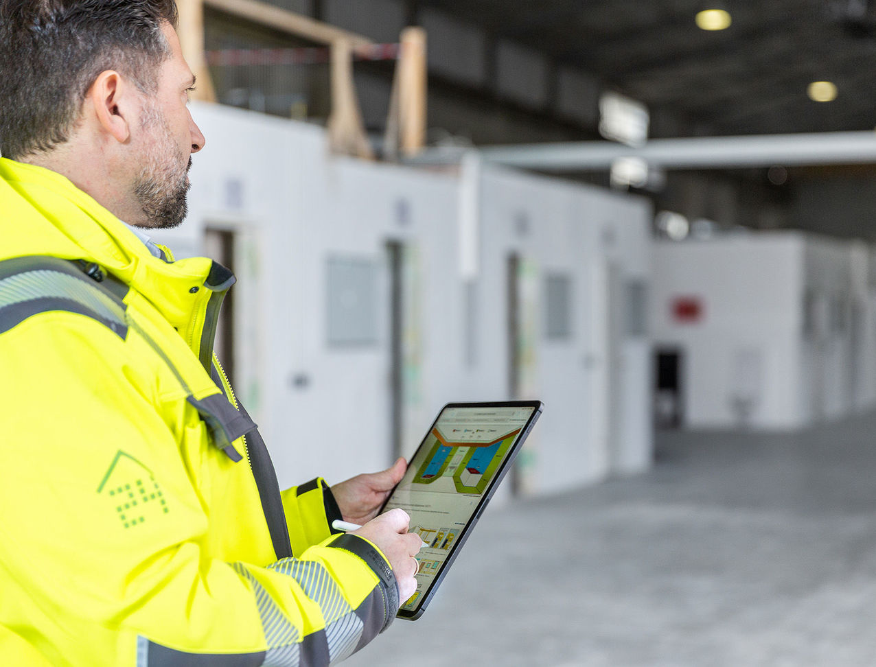 Mitarbeiter von sanierungsprofi24 Bauleiter kontrolliert mit Tablet den Baufortschritt