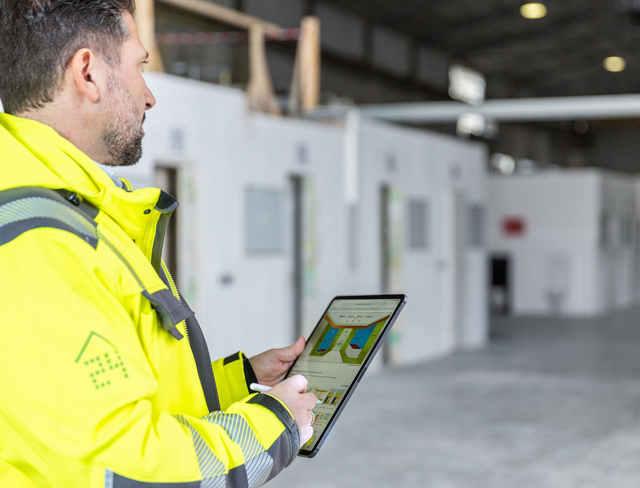 The construction manager monitors the construction progress with a tablet