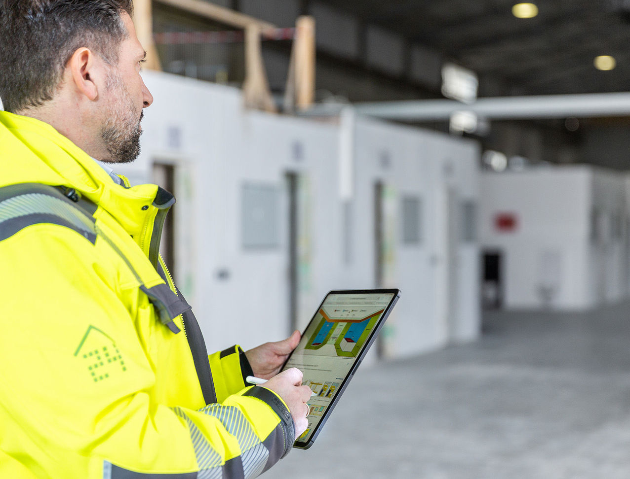 employee of sanierungsprofi24 The construction manager monitors the construction progress with a tablet