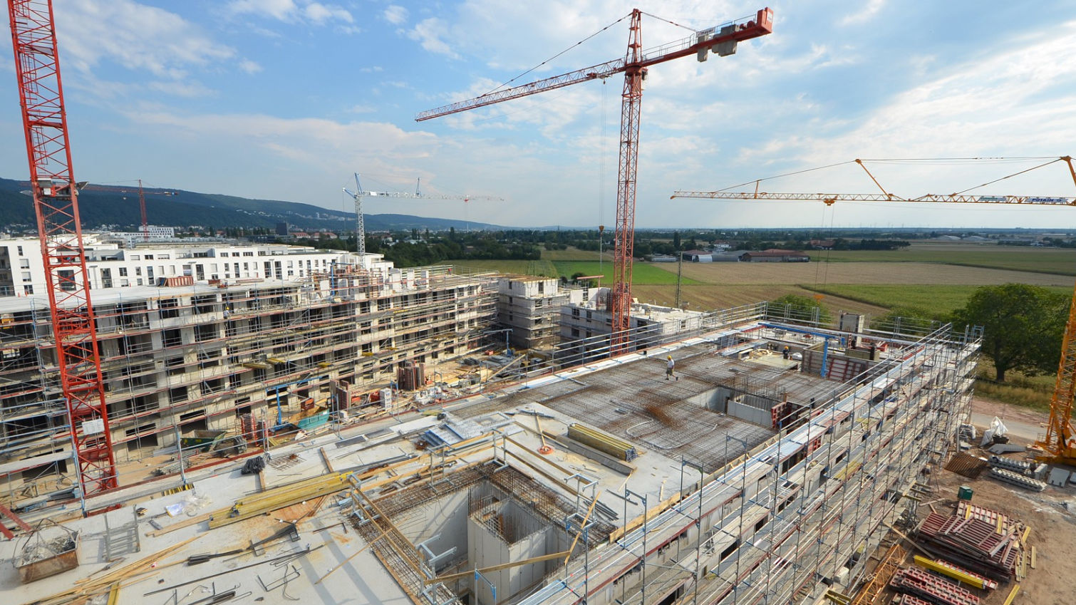 Large construction site from above with three cranes