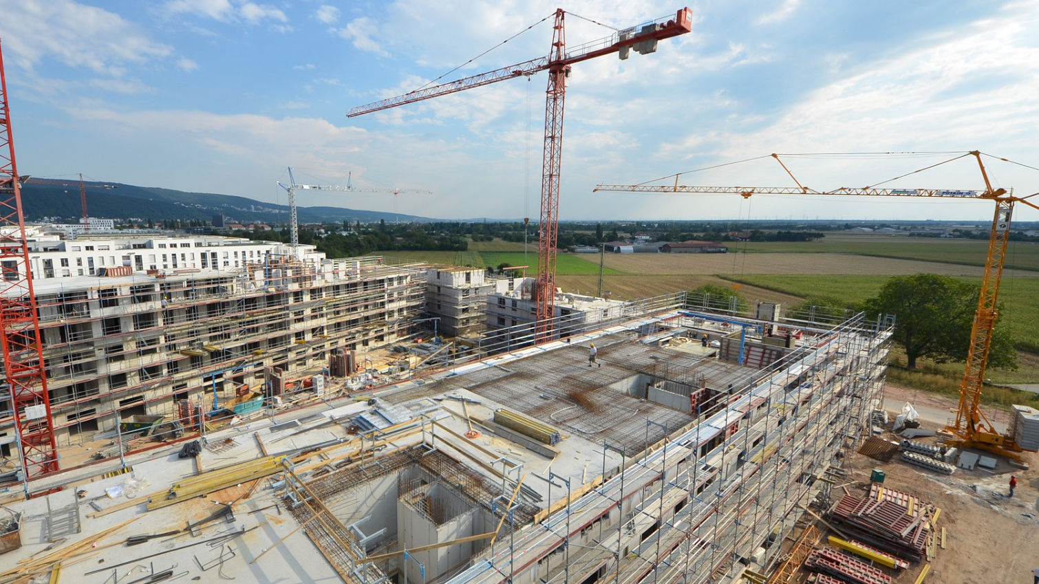 Große Baustelle von oben mit drei Kränen