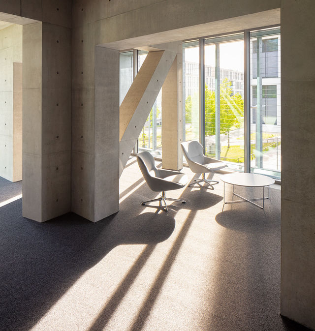 Licht fällt durch die Fenster auf eine gemütliche Sitzgruppe umgeben von einer Fachwerkkonstruktion.
