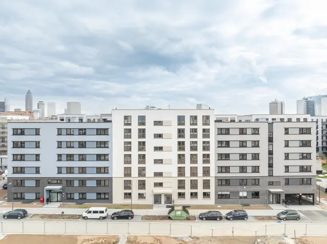 View of a modern residential complex with several apartments of the weisenburger group in Frankfurt under a cloudy sky.