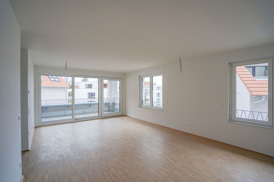 Großer Wohnbereich mit Holzboden und einem Balkon