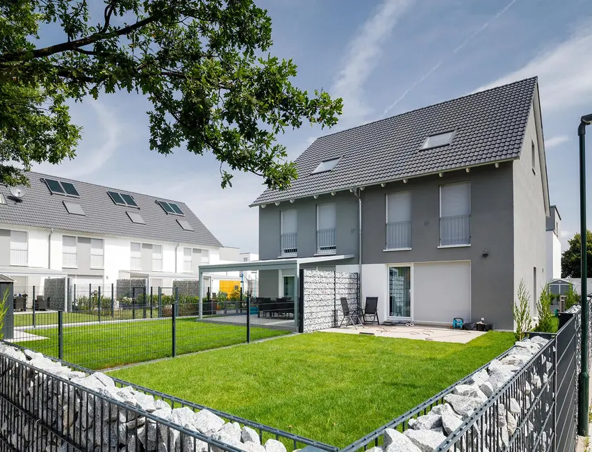 Semi-detached houses painted gray with pitched roofs and gardens