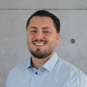 Portraitfoto von einem Mann vor einer Betonwand
