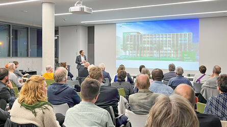 viele Mitglieder der Architektenkammer sitzen in einem Raum und hören einem Vortrag zu