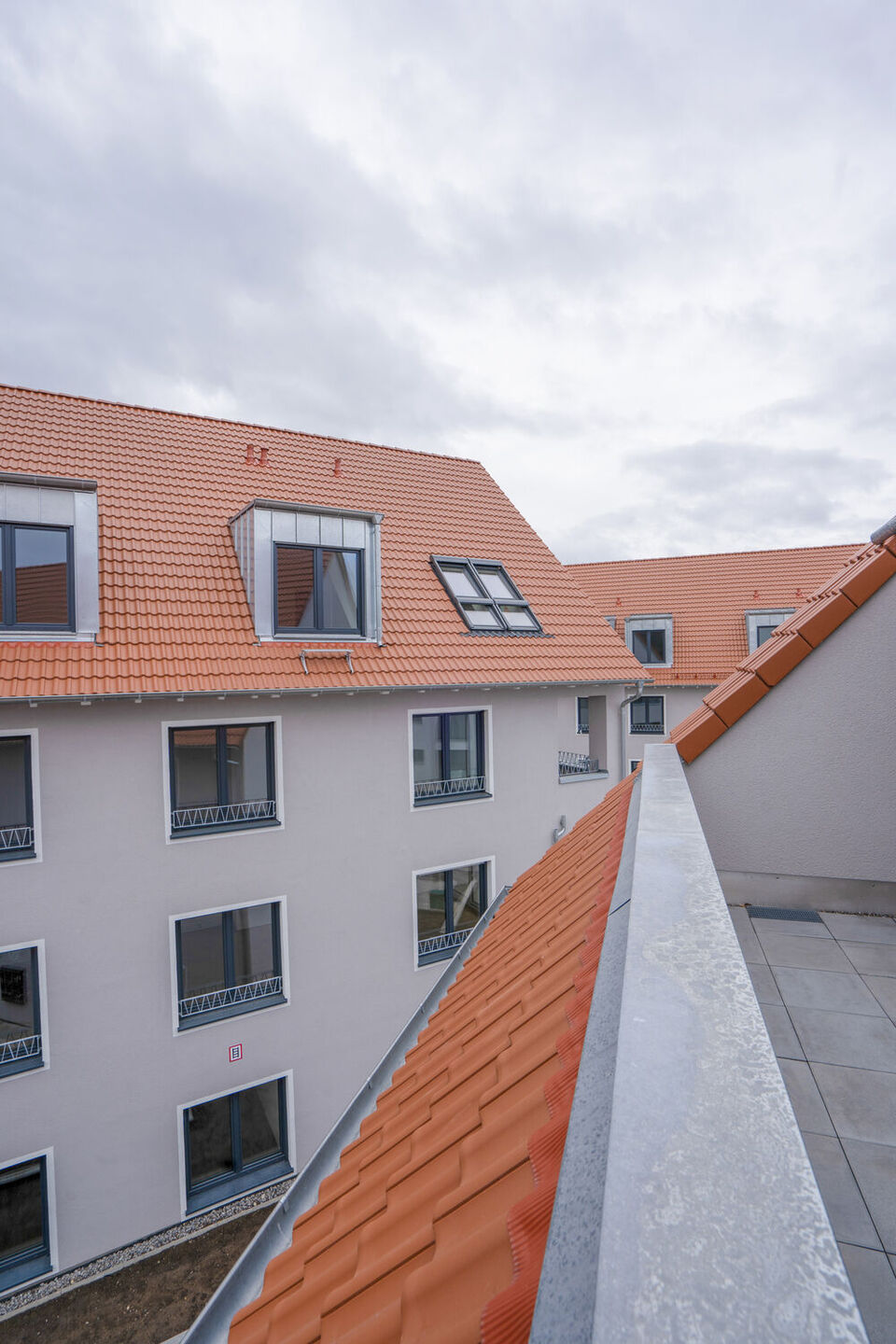 Außenansicht von Mehrfamilienhäusern mit orangenen Ziegeln auf dem Dach