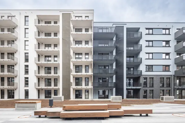 Moderne Wohnanlage mit Balkonen Neubau-Wohnanlage der weisenburger-Gruppe mit hellen Fassaden und Balkonen. Im Vordergrund Sitzgelegenheiten für Bewohner.