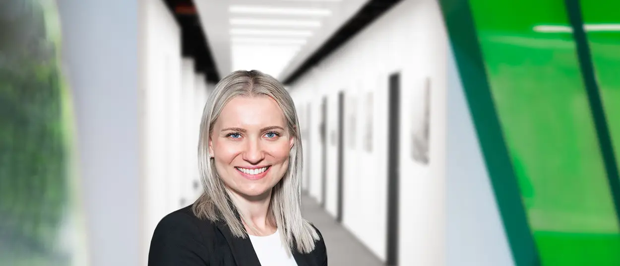 Eine Frau im Bemusterungszentrum schaut in die Kamera und hat ein Tablet in der Hand