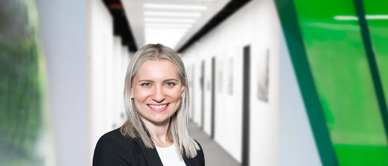 Eine Frau im Bemusterungszentrum schaut in die Kamera und hat ein Tablet in der Hand
