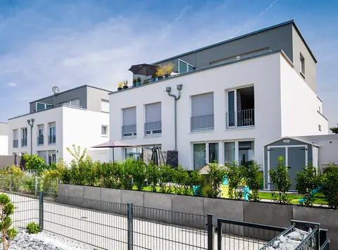 Mehrere Doppelhaushaelften mit Flachdaechern und gruenen Gaerten