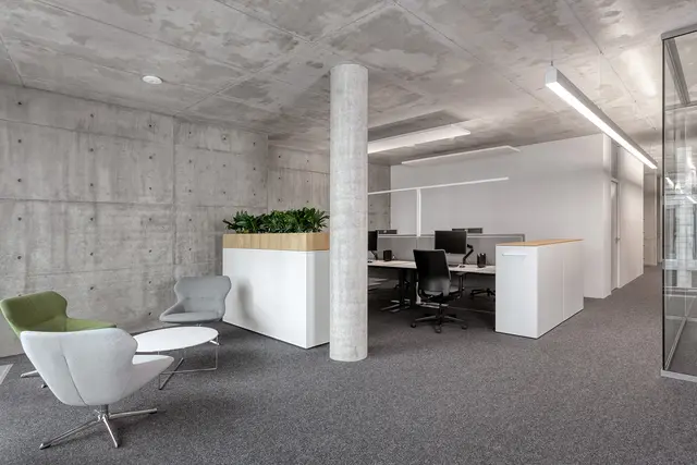 Blick in ein Open Space Büro mit Arbeitsplatz und Sitzgelegenheit