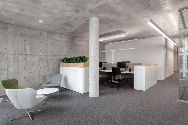 View into an open space office with a workplace and seating
