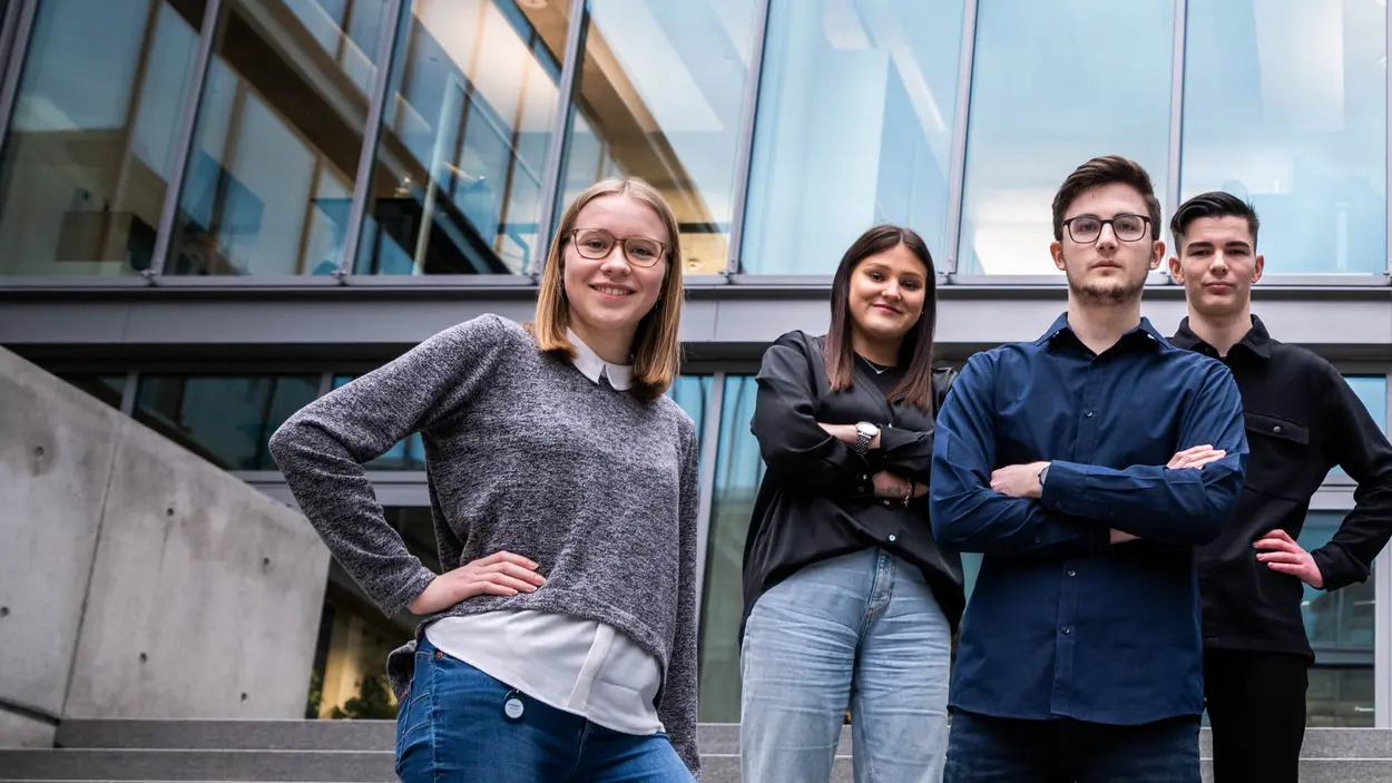 Studenten und Auszubildende bei einem Foto-Shooting Zwei junge Frauen und zwei junge Männer stehen im Innenhof der weisenburger Unternehmenszentrale