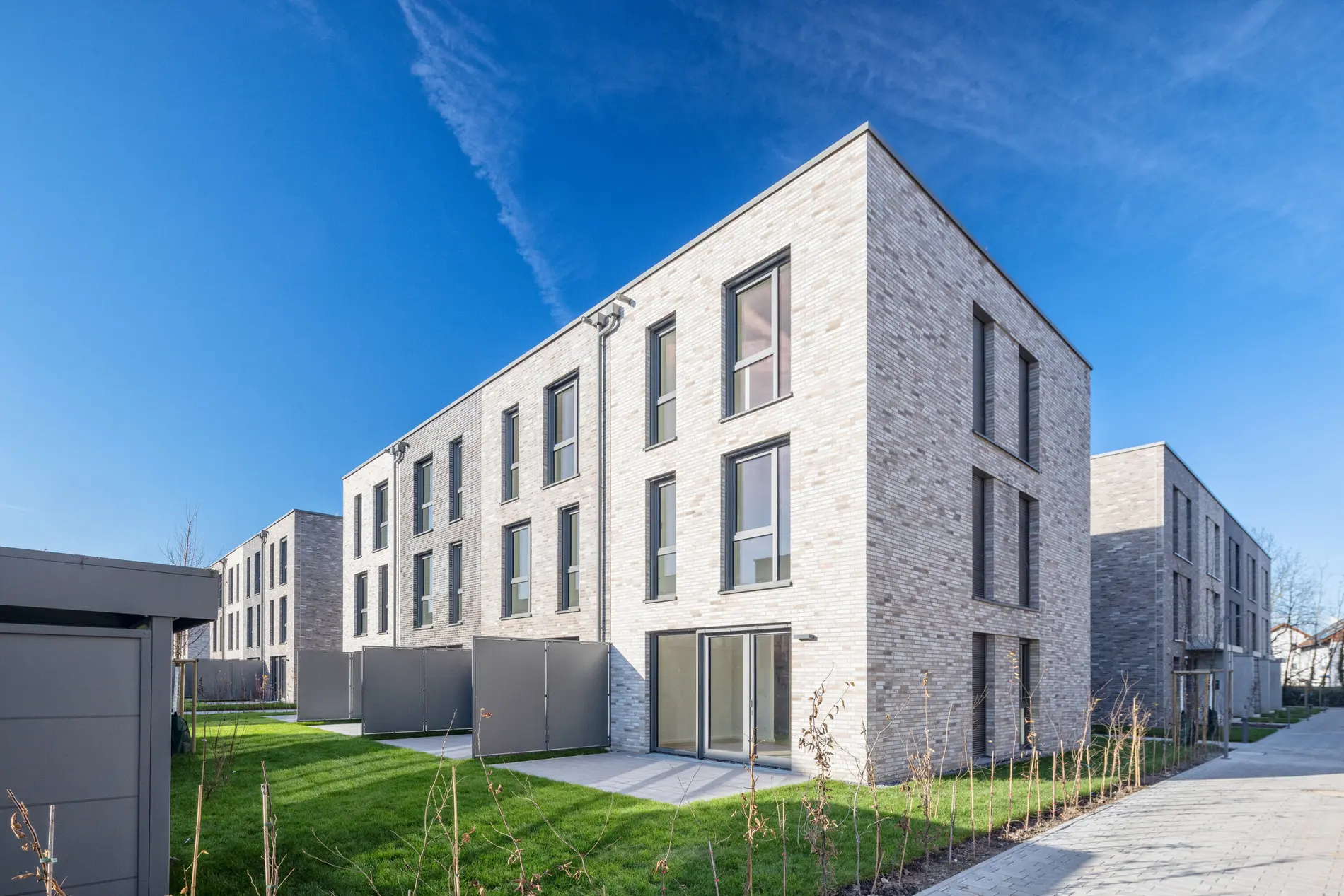 Ein Reihenhaus mit Flachdach und Sichtschutz der weisenburger bau GmbH in Wiesloch