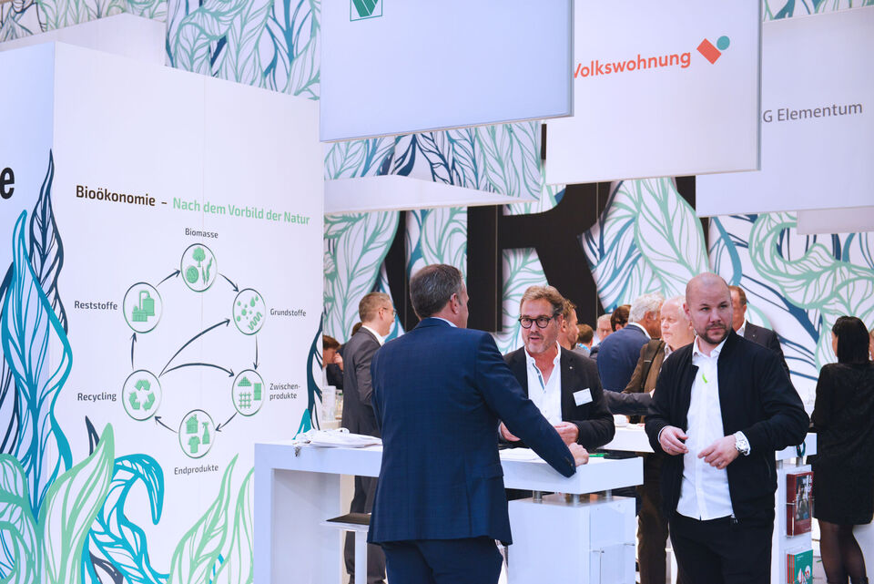 Mitarbeiter von weisenburger stehen an einem Stand auf der Expo Real Messe und unterhalten sich