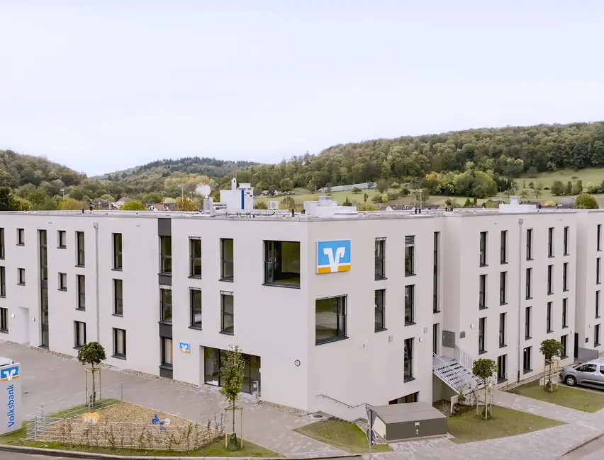 moderne Gewerbeeinrichtung mit weißer Hausferssade bei blauem Himmel 