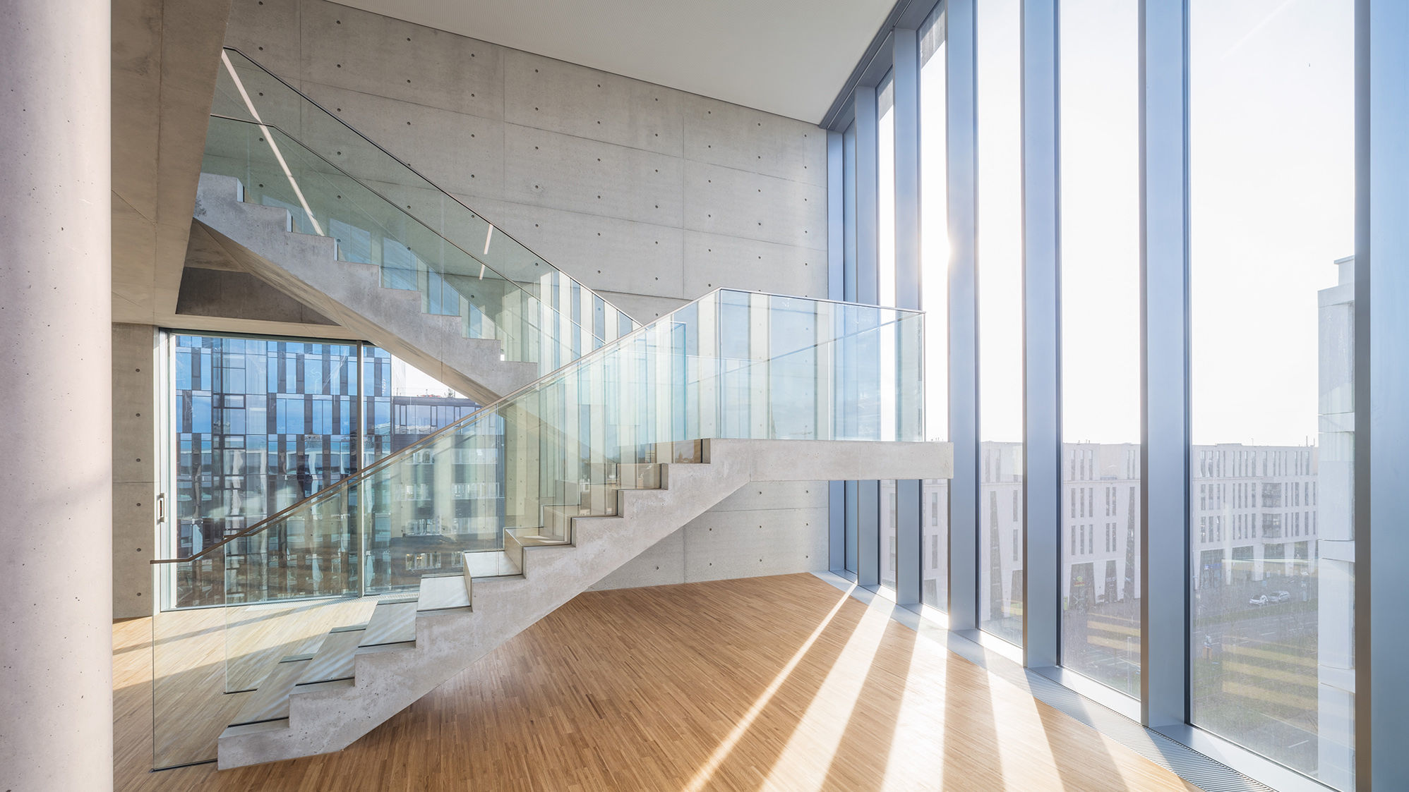 Light floods the skylounge, which connects the upper two floors with an exposed concrete staircase.
