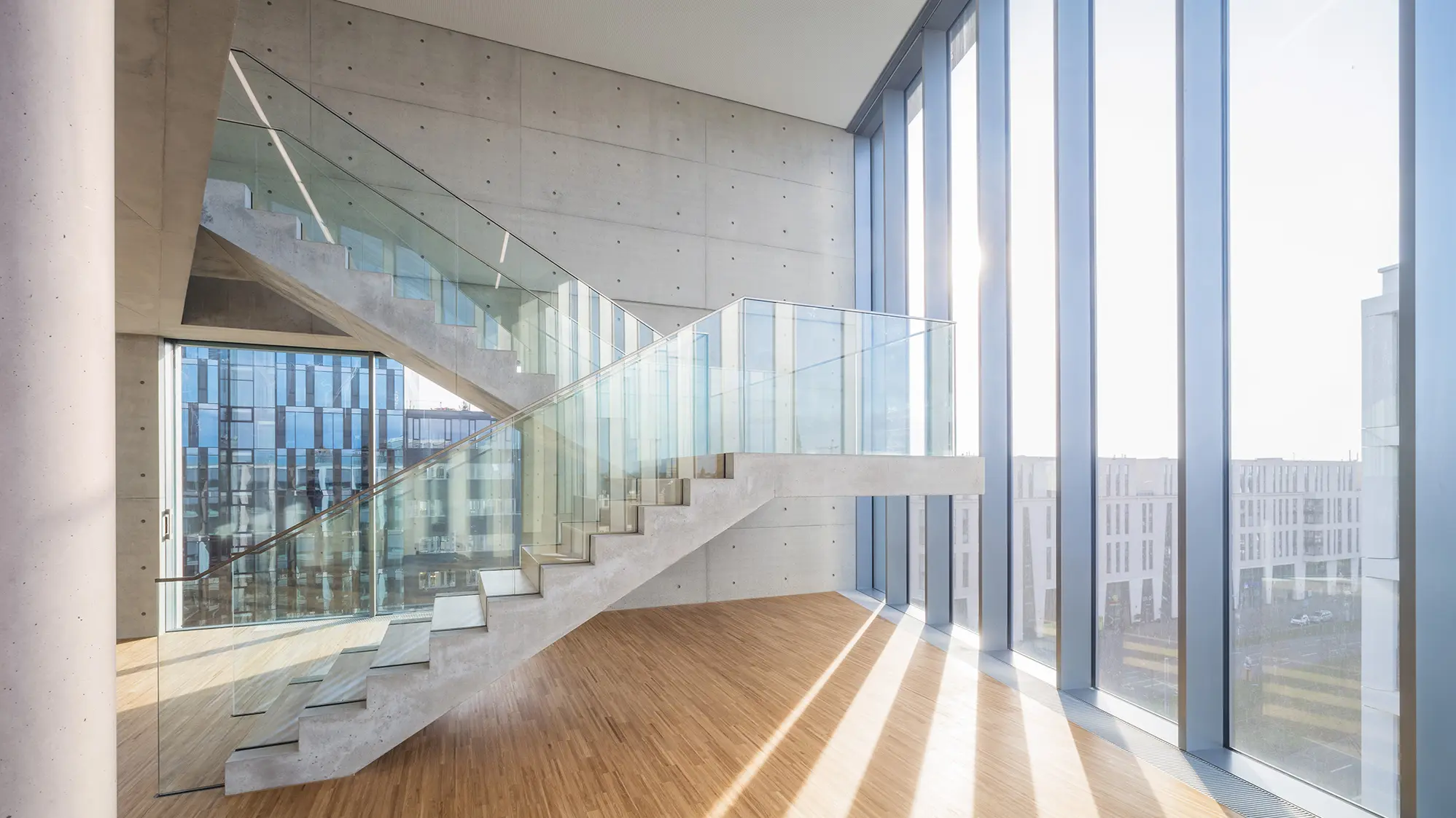 Light floods the skylounge, which connects the upper two floors with an exposed concrete staircase.
