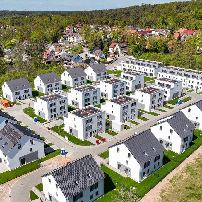 großes Baufeld auf dem viele Reihenhaeuser stehen 