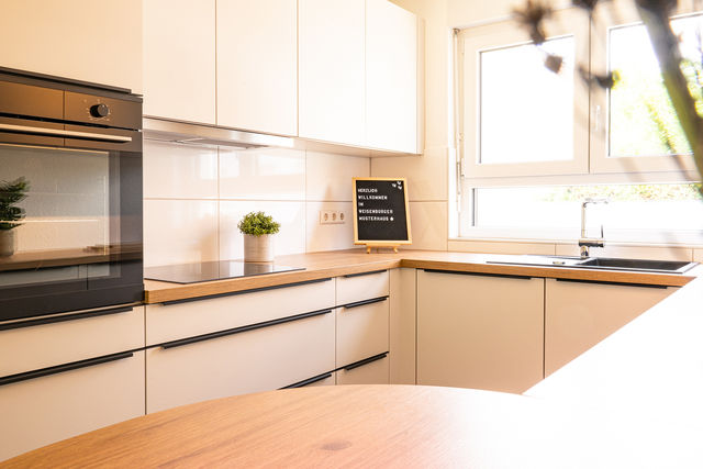 White fitted kitchen with wooden worktop