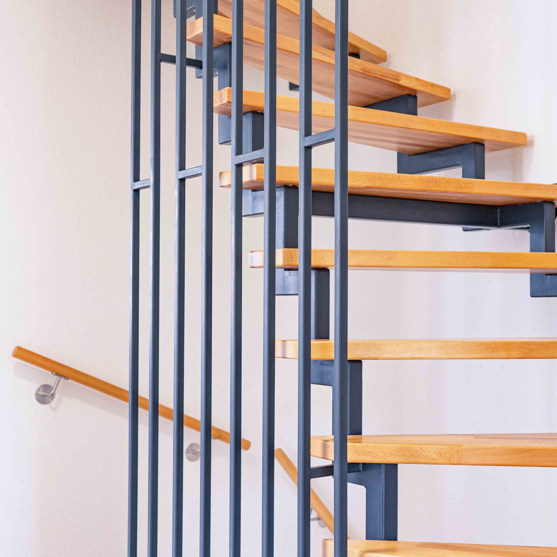  Staircase with light wooden steps and a black railing in a terraced house