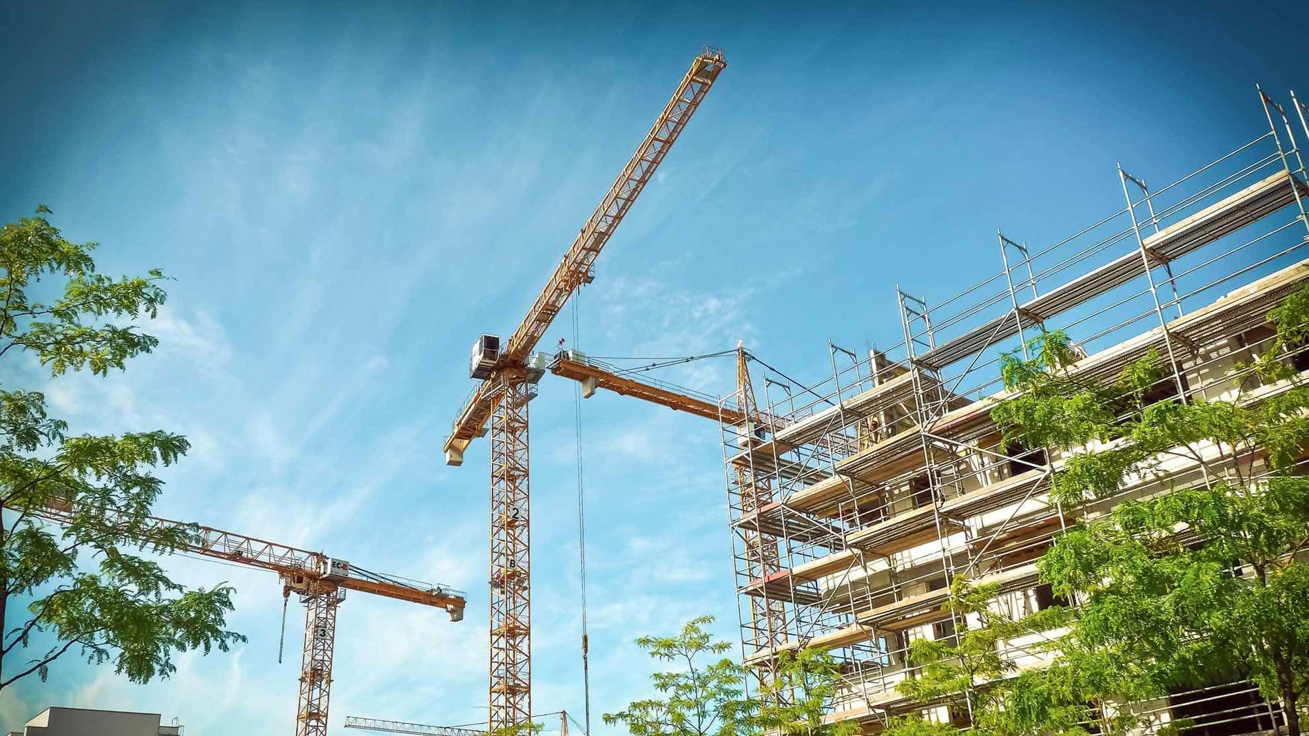 construction site with two cranes at the day with a blue sky