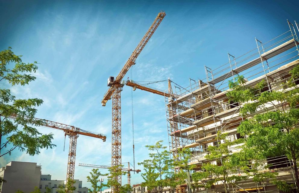 construction site with two cranes at the day with a blue sky