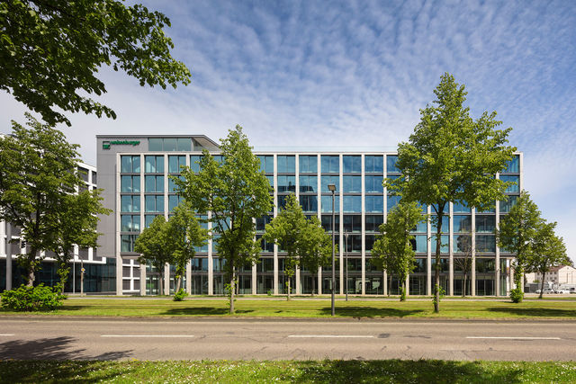 Frontal view of the south facade of the new weisenburger´s headquarter with green trees