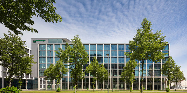 Frontal view of the south facade of the new weisenburger´s headquarter with green trees