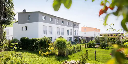 Row houses Emmendingen Four row houses painted gray and white with green gardens