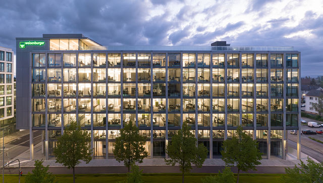 weisenburger-Zentrale in Karlsruhe entworfen von Tadao Ando bei Daemmerung mit beleuchteten Bueros 