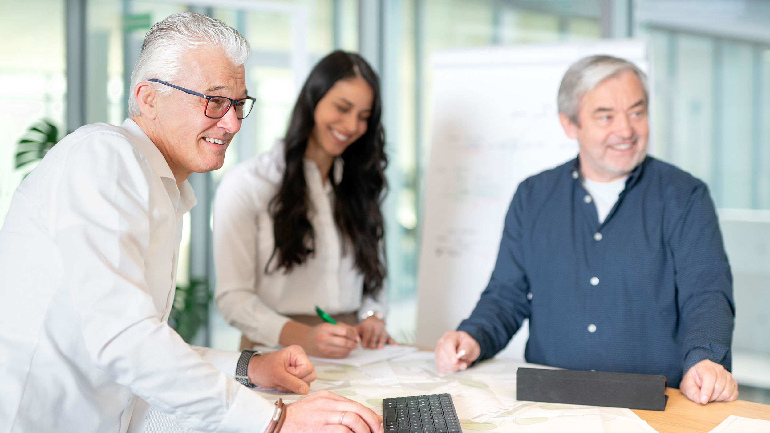 Drei Mitarbeiter der Projektentwicklung halten ein Meeting ab