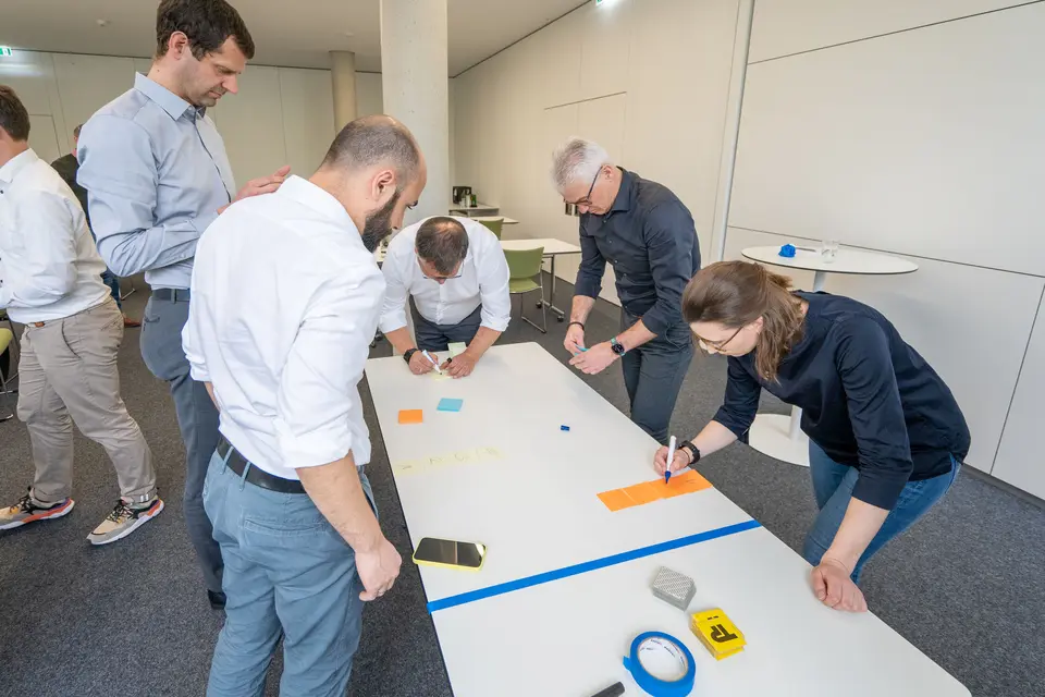 Several weisenburger employees stand in front of a table and write notes to compile a complete result