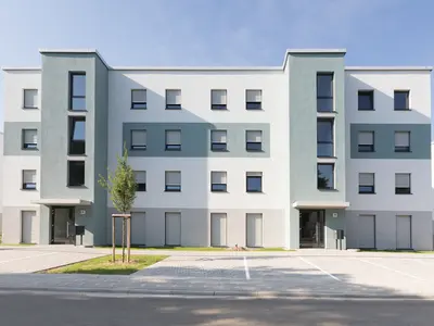 Mehrfamilienhaus mit vielen Wohneinheiten und Stellplaetzen direkt vor der Eingangstuer