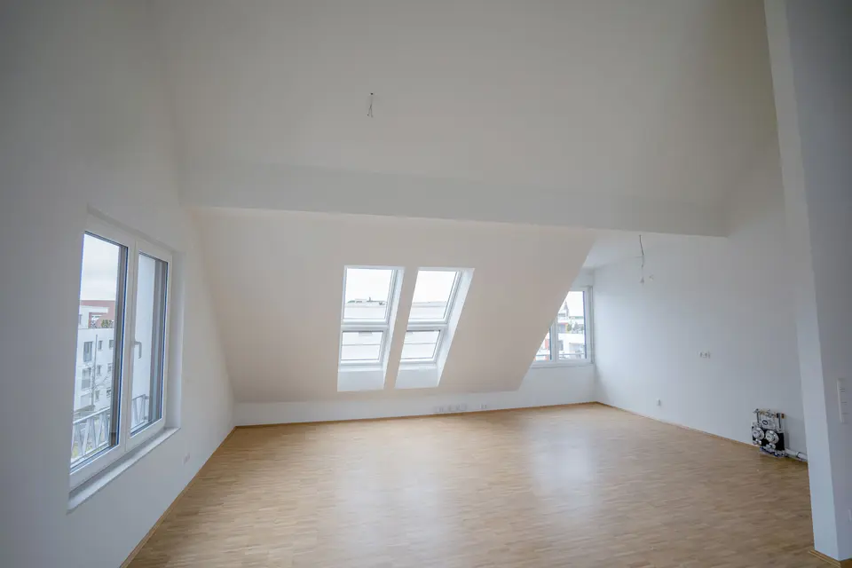Bright attic room with wooden floor and windows built by weisenburger