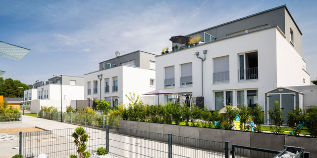 Modern semi-detached houses with flat roofs and green gardens