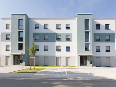 Mehrfamilienhaus mit vielen Wohneinheiten und Stellplaetzen direkt vor der Eingangstuer