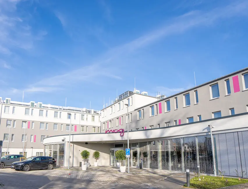 Außenansicht vom Moxy Hotel in Karlsruhe mit Stellplatzen direkt vor der Eingangstuer 