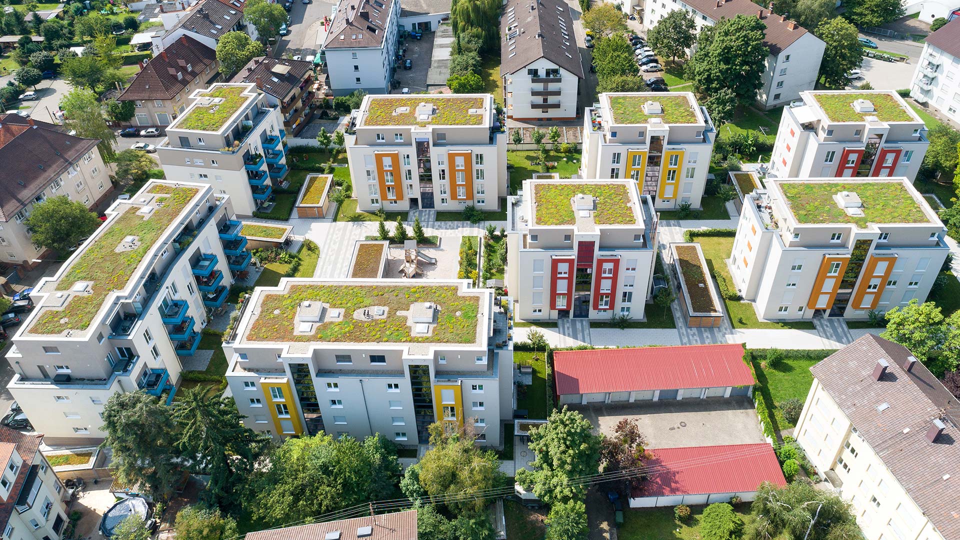 Wohnungsanlagen mit Mehrfamilienhaeusern mit Gruendach aus der Vogelperspektive 